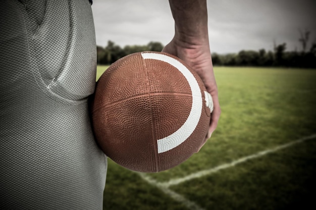 Samengestelde afbeelding van American football-speler met bal