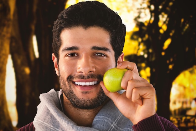 Samengestelde afbeelding van close-up portret van lachende man met apple