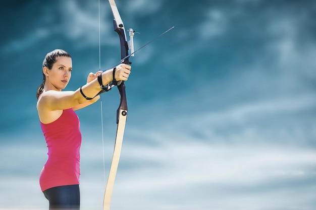 Samengestelde afbeelding van sportvrouw die boogschieten beoefent op een witte achtergrond