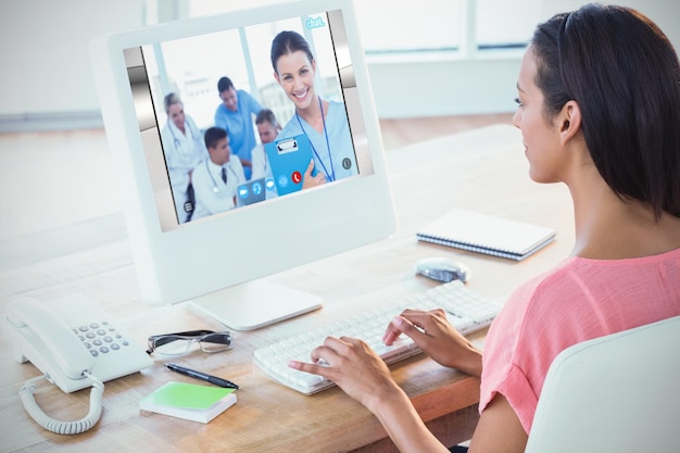 Samengestelde afbeelding van zakenvrouw met behulp van computer aan bureau in creatief kantoor