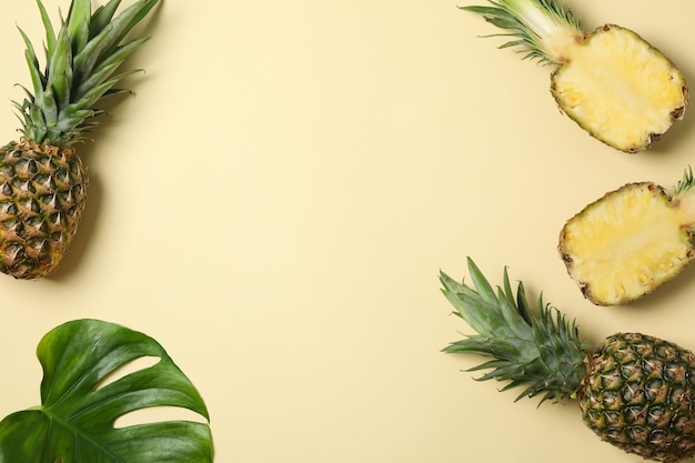 Samenstelling met ananas en palmtak op beige achtergrond, ruimte voor tekst