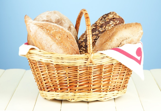 Samenstelling met brood en broodjes op houten tafel, op kleurenmuur