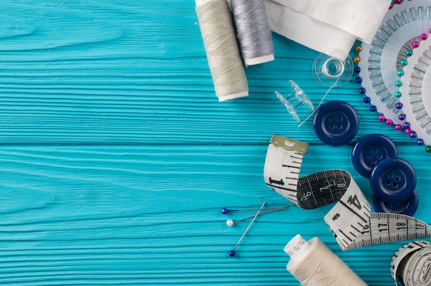 Samenstelling met draden en naaiende accessoires op blauwe achtergrond