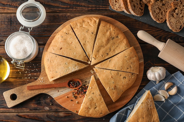 Samenstelling met flatbread en keuken accessoires op houten ruimte, bovenaanzicht