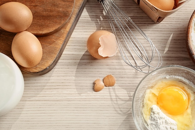 Samenstelling met garde en ingrediënten op houten tafel