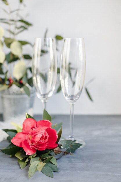 Samenstelling met glas voor champagne. Bloemen en harten op grijze betonnen achtergrond.