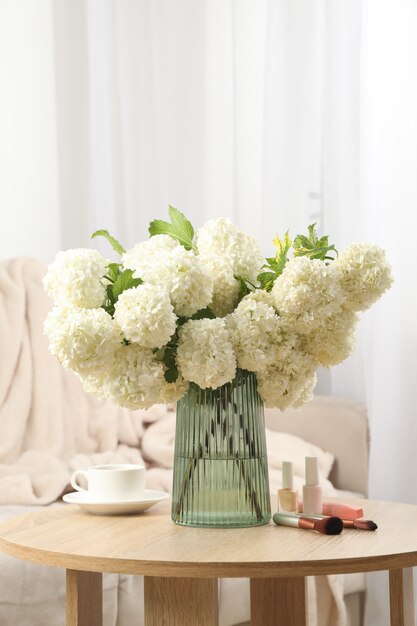 Samenstelling met hortensia bloemen, kopje koffie en cosmetica. Lente plant