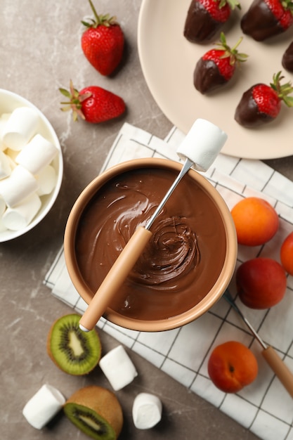 Samenstelling met ingrediënten voor chocoladefondue op grijze tafel. Fondue koken