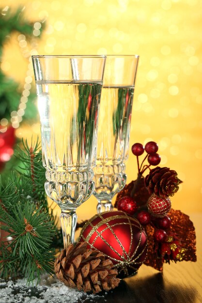 Samenstelling met kerstversiering en twee champagneglazen, op lichte achtergrond