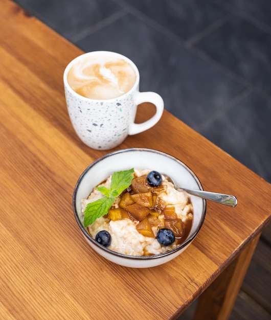 Samenstelling met kom havermout en koffie Gezond en smakelijk ontbijt met havermoutpap