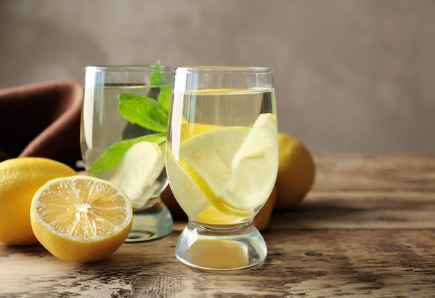 Samenstelling met koud citroenwater op een houten tafel