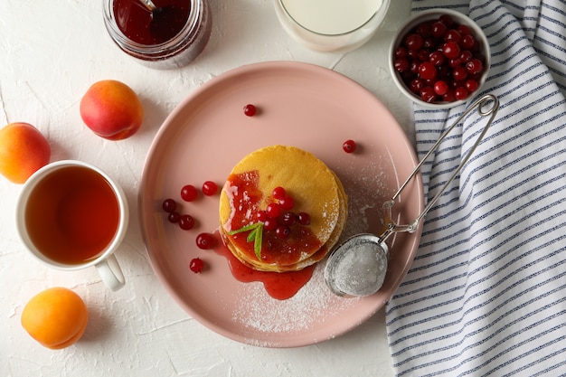 Samenstelling met pannenkoeken met jam en cranberry op witte ruimte