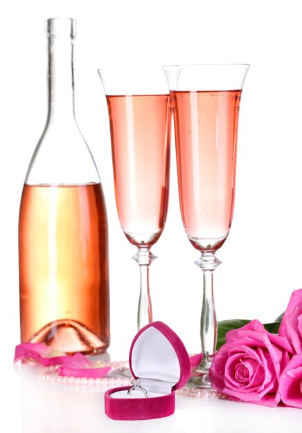 Samenstelling met roze mousserende wijn in glazen, fles en roze rozen geïsoleerd op wit