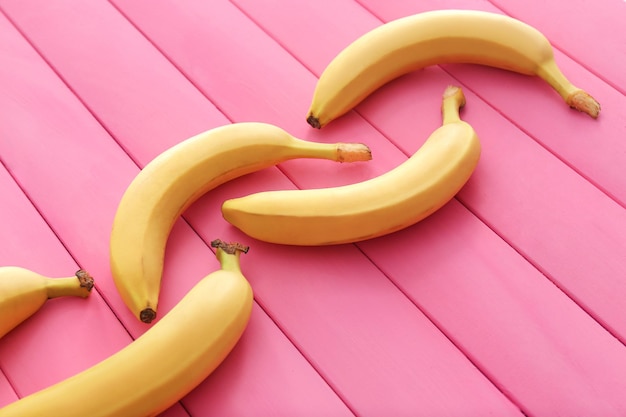 Samenstelling met smakelijke rijpe bananen op een houten achtergrond kleur