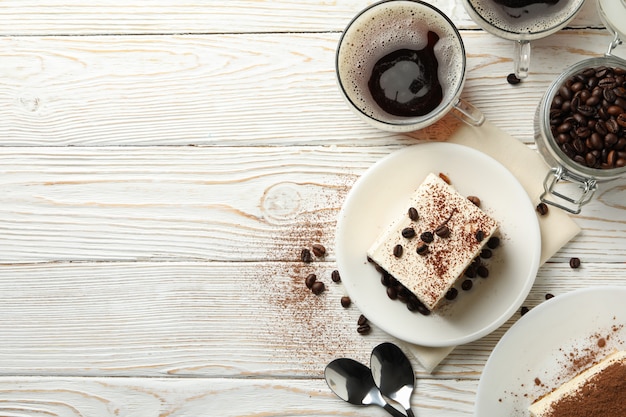 Samenstelling met smakelijke tiramisu op witte houten achtergrond. heerlijk toetje