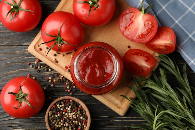 Samenstelling met tomaten en saus op houten achtergrond. Rijpe groente