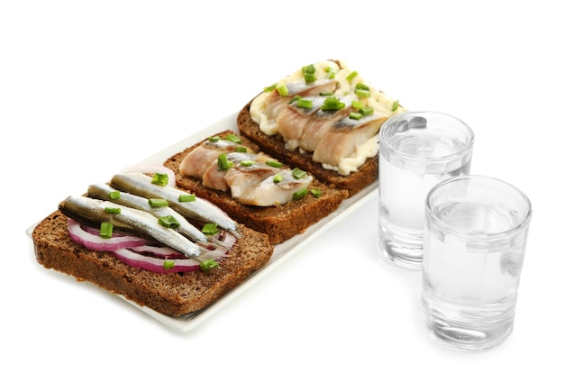 Samenstelling met twee glazen wodka en sandwiches met gezouten vis geïsoleerd op wit