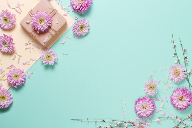 Samenstelling van bloemen met bloemen en geschenkdoos op een pastel achtergrond