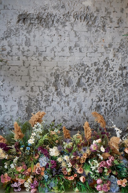 Foto samenstelling van bloemen tegen de achtergrond van een grijze muur floristiek in het ontwerp van de kamer droge bloemen