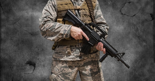 Samenstelling van de buik van een soldaat die een pistool vasthoudt, tegen rook op een donkere achtergrond