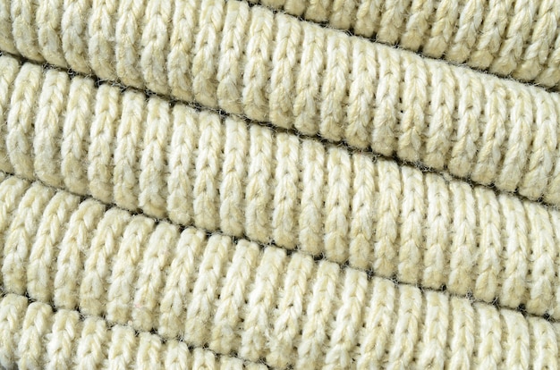 Foto samenstelling van een zachte gele gebreide trui. macrotextuur van banden in garens