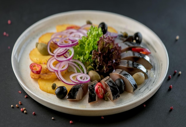 Samenstelling van gezouten makreel met garnituur aardappelen uien geserveerd op een houten bord