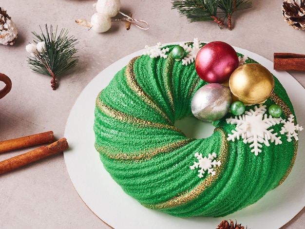 Foto samenstelling van groene kerstmiscake met kegels en kaneel