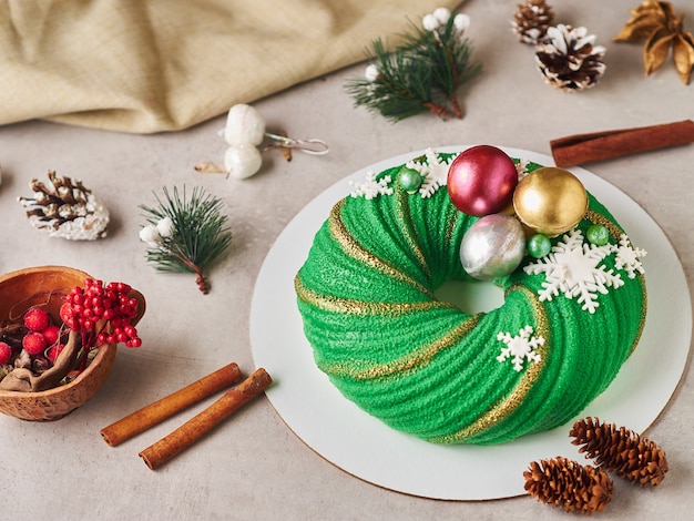 Foto samenstelling van groene kerstmiscake met kegels en kaneel