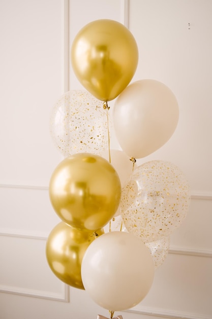 Foto samenstelling van heliumballonnen wit transparant met ook confetti en een grote figuur van een gouden kleuren cadeau voor 1 jaar