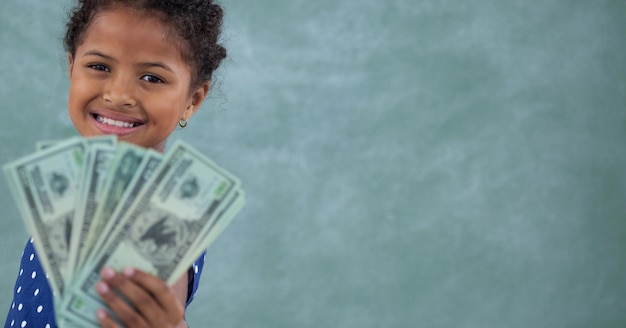 Samenstelling van lachend meisje met Amerikaanse dollarbiljetten op groene achtergrond