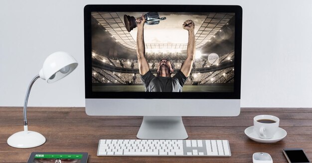 Samenstelling van mannelijke rugbyspeler met beker in rugbystadion op computer