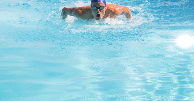 Samenstelling van mannelijke zwemmer in zwembad met helder water, gloeiend licht en kopieerruimte