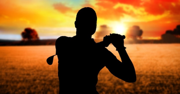 Foto samenstelling van silhouet van mannelijke golfspeler over landschap en ondergaande zon met kopieerruimte