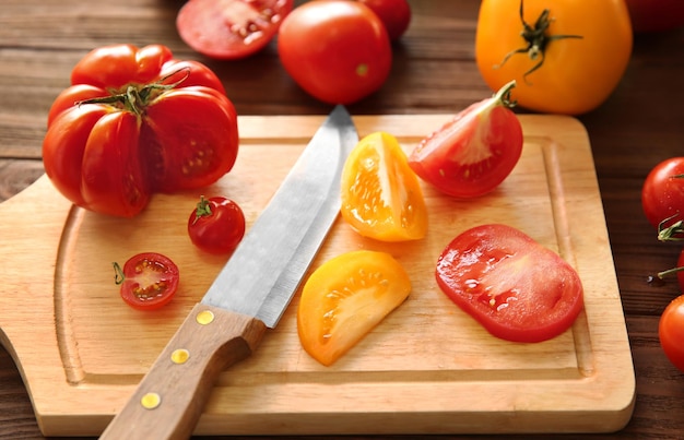 Samenstelling van tomaten en plakjes op houten snijplank