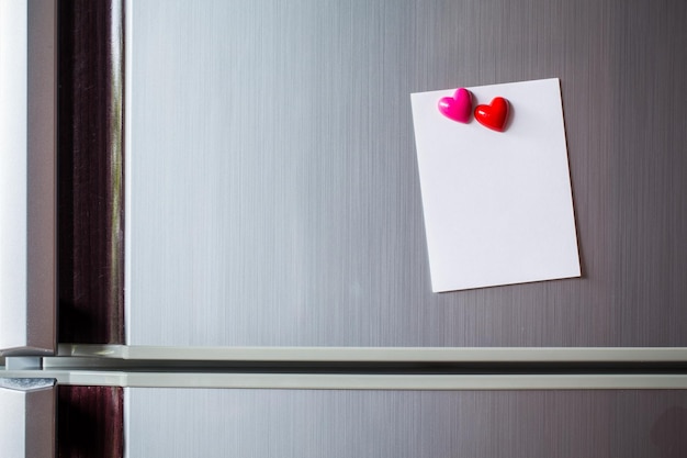 Samenvatting van houten hartclip met blanco papier en plakpapier op koelkastdeur papier notitie kopie ruimte voor tekst valentijn afbeelding bericht achtergrond toevoegen