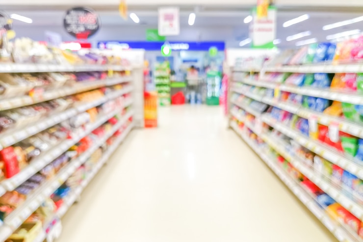 Foto samenvatting wazig gangpad van de supermarkt met kleurrijke planken en onherkenbare klanten