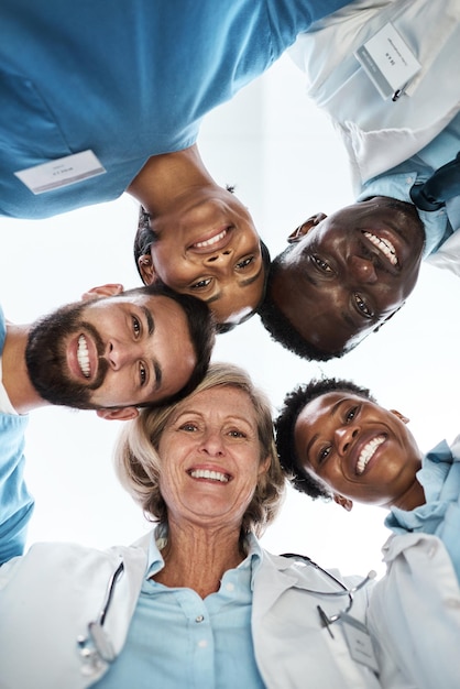 Samenwerkend om hoogwaardige gezondheidszorg voor iedereen te bieden Portret van een groep artsen die samen in een huddle staan