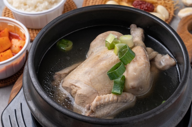 Куриное блюдо Samgyetang моллюска восточная медицина nurungji глиняный горшок корейская еда здоровое питание гарнитуры чеснок