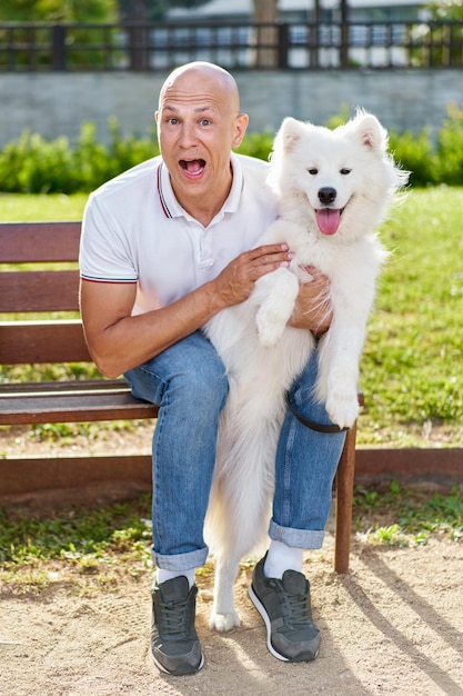 Foto samojeed hond met haar baasje in het park samen spelen