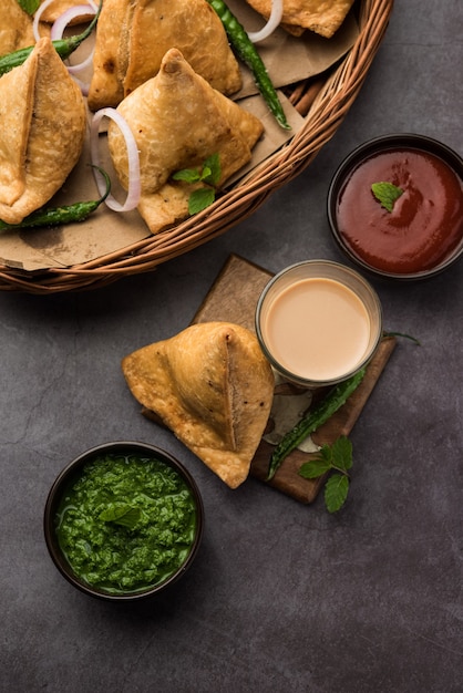 Samosa - Driehoekig gefrituurd / gebakken deeg met hartige vulling, populaire Indian Tea Time-snacks, geserveerd met groene chutney, tomatenketchup