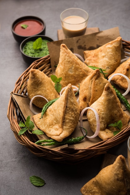 Samosa - Driehoekig gefrituurd / gebakken deeg met hartige vulling, populaire Indian Tea Time-snacks, geserveerd met groene chutney, tomatenketchup