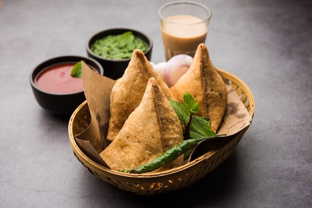 Samosa - Driehoekig gefrituurd / gebakken deeg met hartige vulling, populaire Indian Tea Time-snacks, geserveerd met groene chutney, tomatenketchup