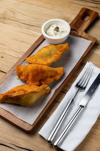 Samosas are served on a wooden board