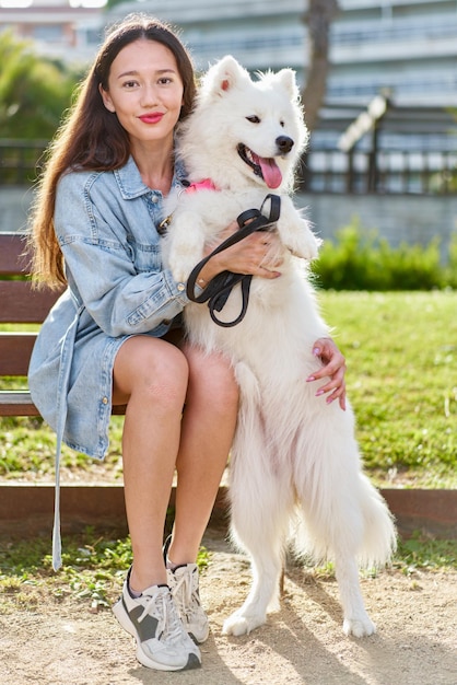 Cane samoiedo con la sua proprietaria al parco che giocano insieme