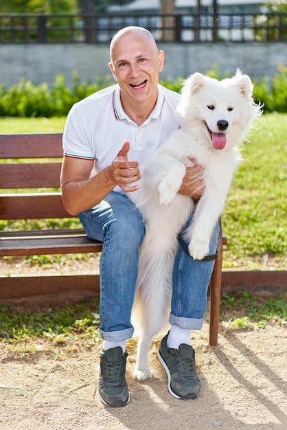 Фото Самоедская собака со своим мужчиной-хозяином в парке играют вместе