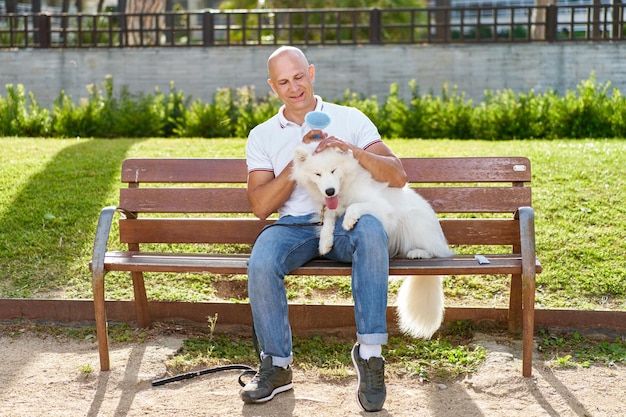 Samoyed dog with her man owner at the park playing together