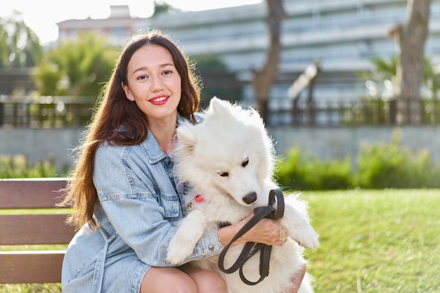 公園で彼女のウーマンの所有者とサモエド犬