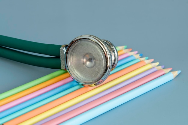 Sample of colored pencils and a stethoscope representing the pediatric doctor