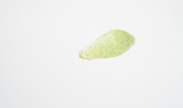 A sample of a natural green scrub on a white background Peeling cream with microcapsules