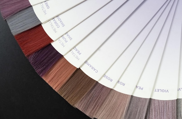 Samples of professional hair dye in a hairdressing salon hair\
coloring in a beauty salon hair dye kit on board with hair samples\
of different colors